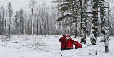 西伯利亚农村俄罗斯妈妈加利娜在雪地庭院中抱着幼儿，背景是白桦树林，画面温暖而质朴充满大地气息